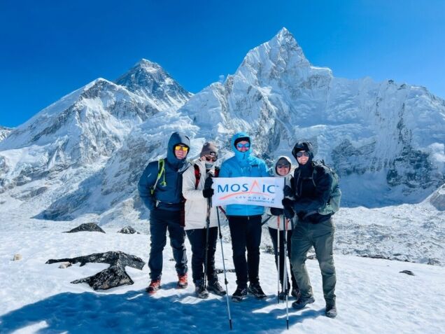 Everest Base Camp with Mount Everest and climbers holding Mosaic Adventure banner in the Khumbu region